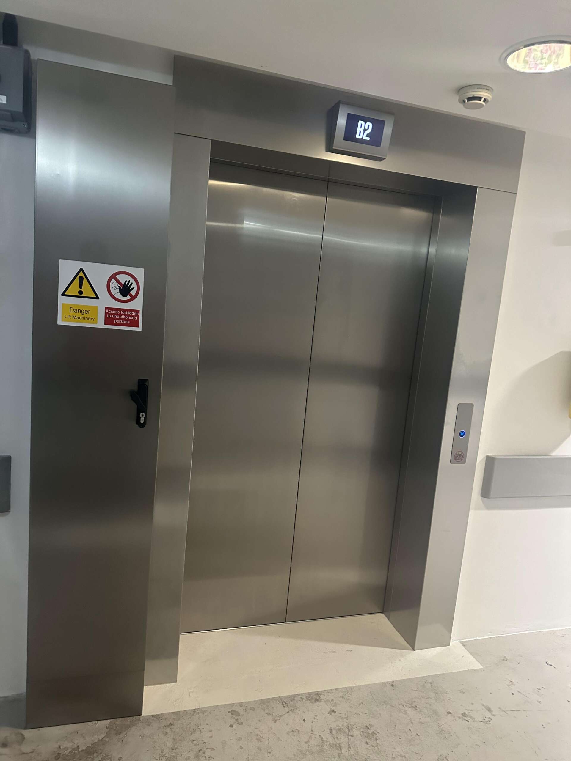 an elevator doors with a warning sign