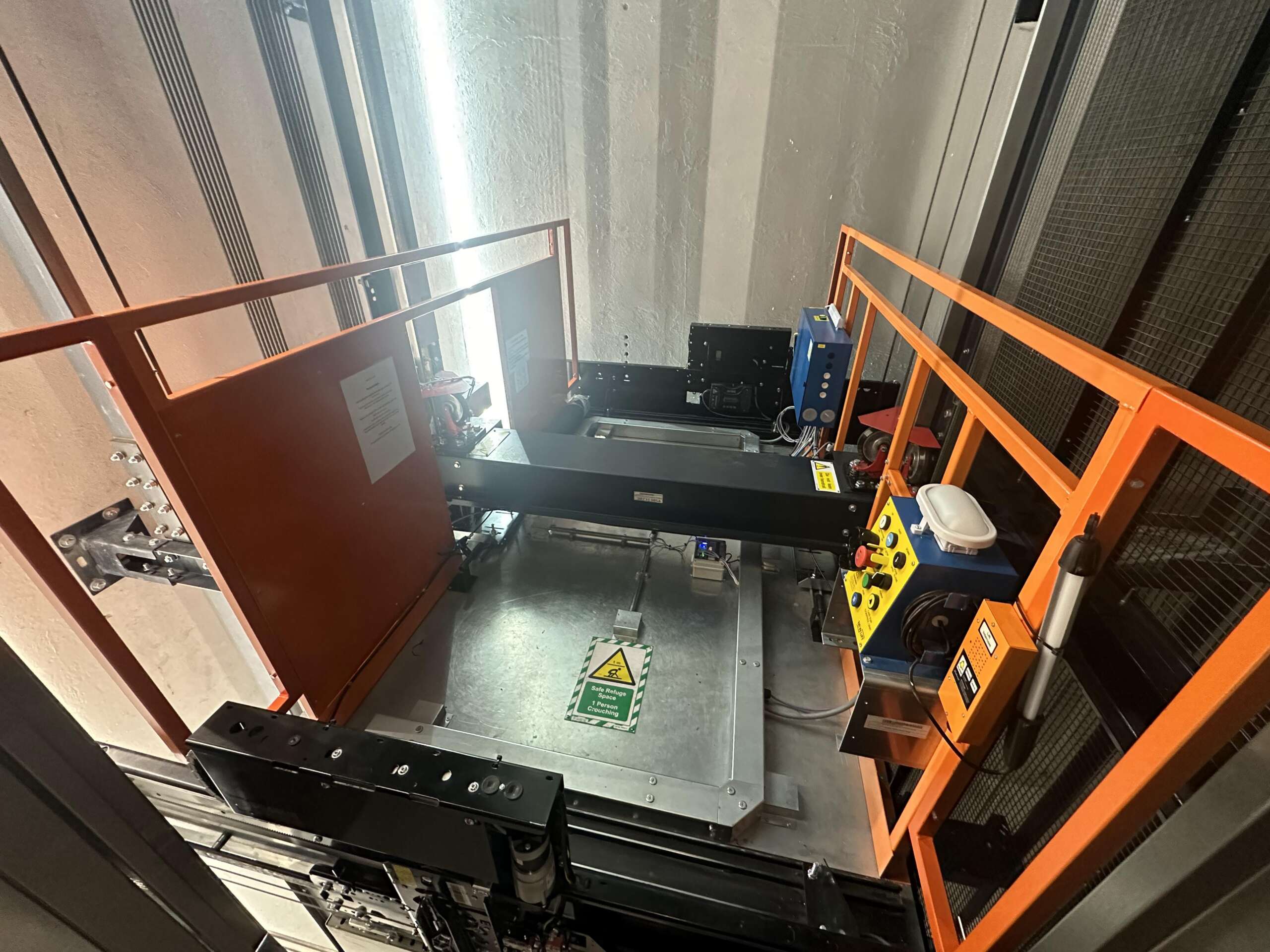 a machine with orange railings and a metal surface