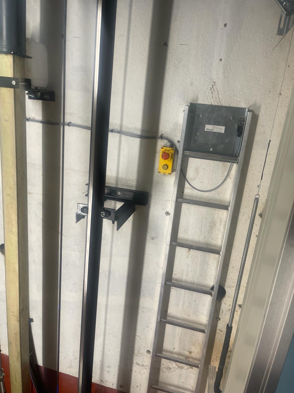 a ladder and a yellow button on a wall