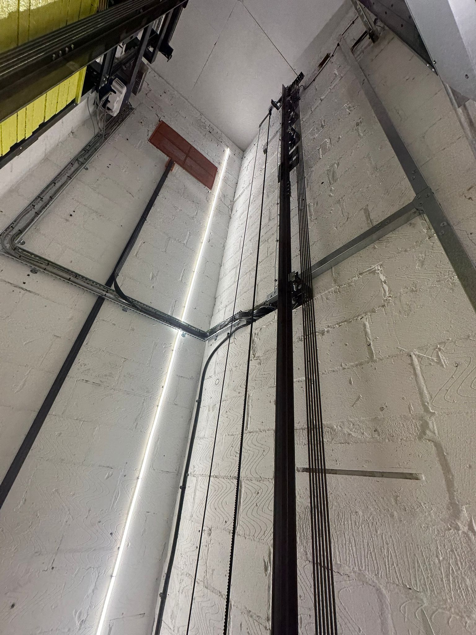 a white brick wall with metal pipes