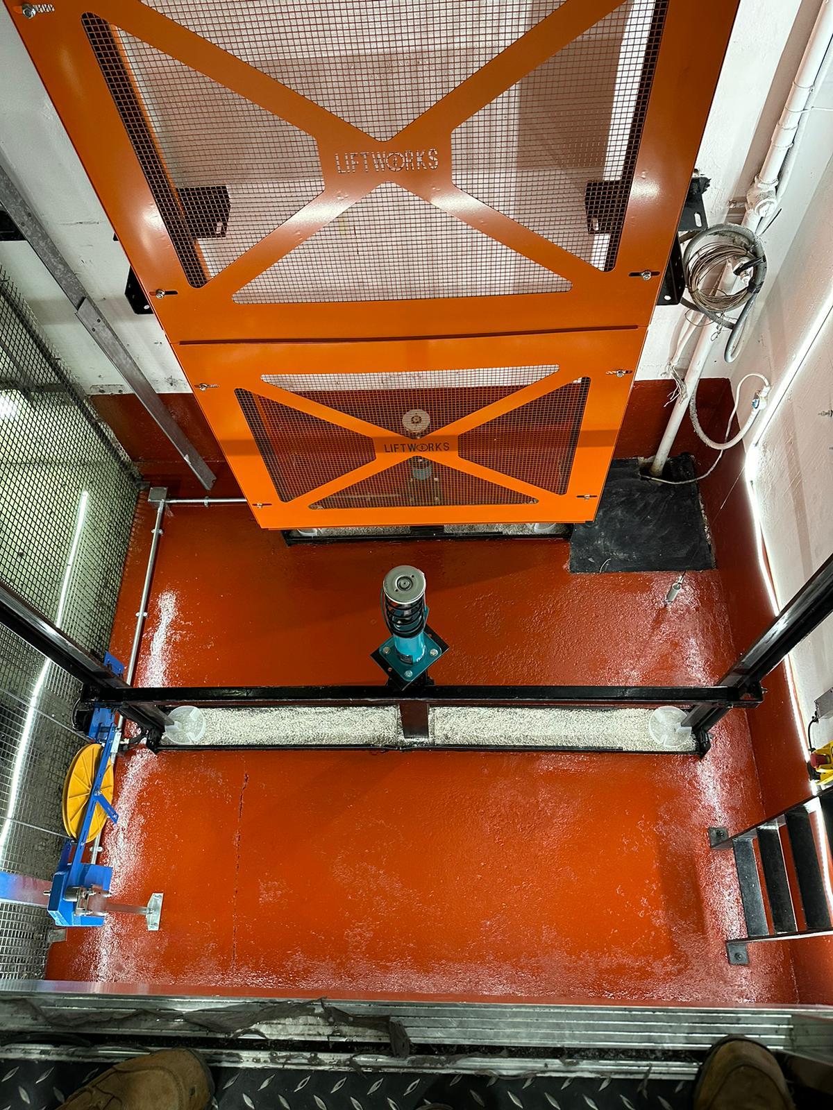 a red floor with a metal gate and a blue object